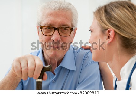 Female nurse talking and taking care of senior old man at hospital