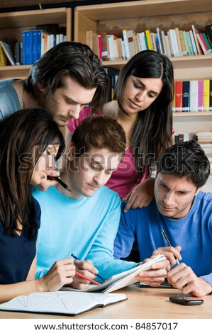 Group of young students working together at college library