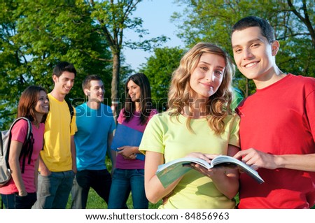 Smiling young group of students studying together outdoor at the college park