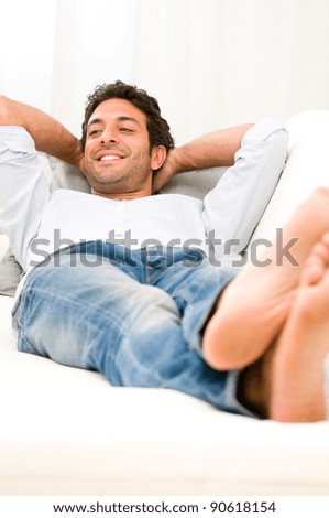 Young man relaxing and taking a break on sofa at home