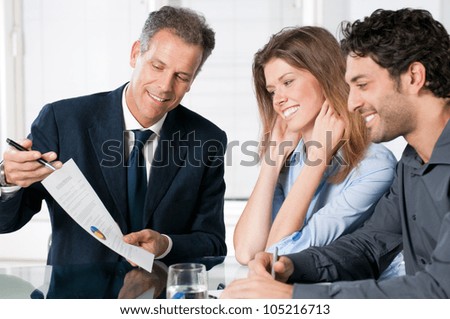 Happy Young Couple Discussing With A Financial Agent Their New Investment