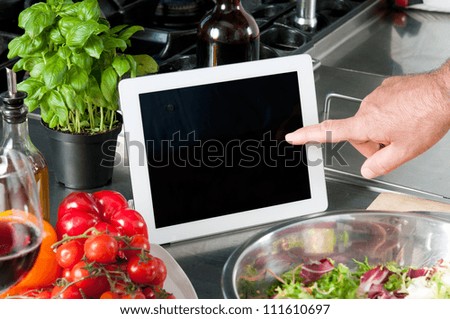 Examine digital recipe on tablet at kitchen to prepare the lunch