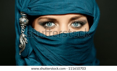 Portrait of an arabic young woman with her beautiful blue eyes in traditional islamic cloth niqab
