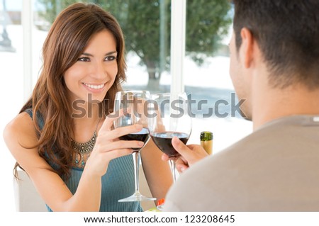 Young Couple Toasting Wine Glass In Restaurant