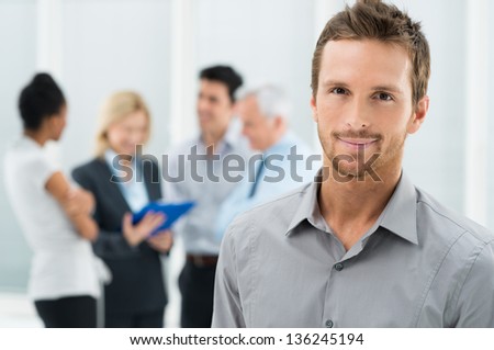 Portrait Of Young Handsome Businessman In Office With Colleagues In The ...