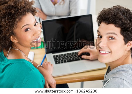 Happy Young Smiling Students Working On Laptop