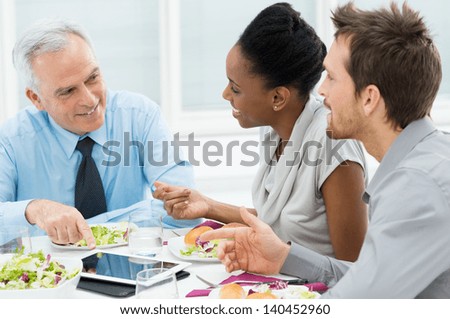 Business Colleagues Eating Meal Together While Discussing Of Work