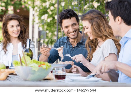 Group Of Happy Young Friends Having Dinner At Patio