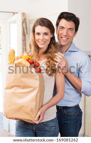 Portrait Of Happy Young Couple With Grocery Bag; Indoor