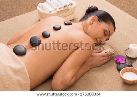 Beautiful Young Woman Receiving Hot Stones Massage At Spa