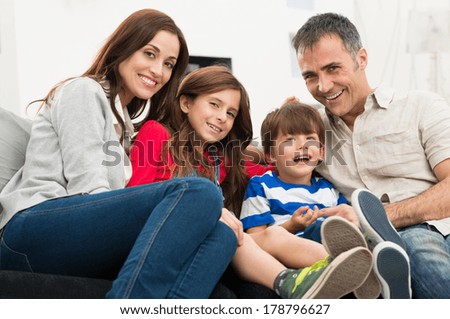 Portrait Of A Happy Smiling Family Sitting On Couch