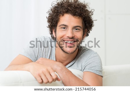 Portrait Of Happy Young Man Sitting On Sofa Portrait Of Happy Young Man Sitting On Sofa