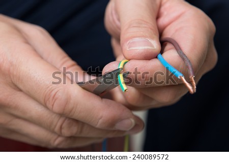 Close Up Of Person Hand With Pliers Cutting Cable