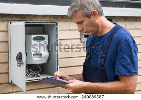 Portrait Of Electrician Worker Inspecting Electric Meter