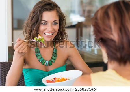 Happy Woman With Salad In Front Of Female Friend At Cafeteria