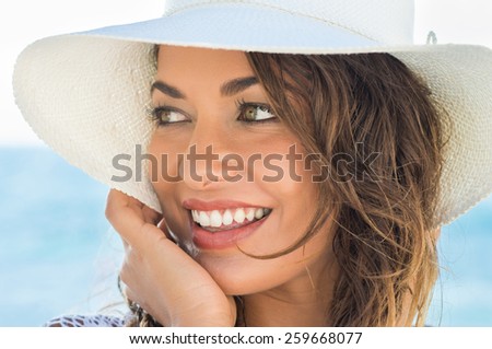 Portrait Of Beautiful Smiling Young Woman At Beach With Sraw Hat