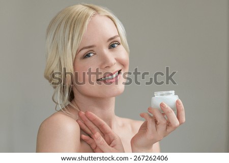 Portrait of beautiful young woman holding body\'s moisturizer