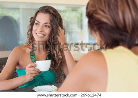 Two Young Beautiful Woman Having Coffee At Bar