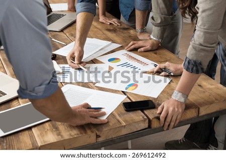 Businessman and woman discussing on stockmarket charts in office
