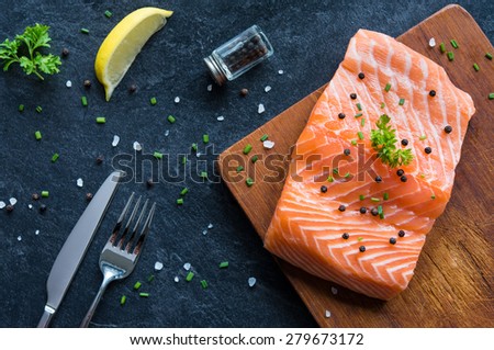 Raw salmon fillet on a wooden cutting board