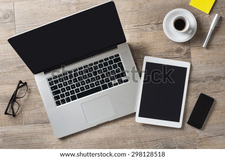 Closeup shot of laptop with digitaltablet and smartphone on desk. Modern devices on desk at office. Three different type of screen to put your responsive web page on.