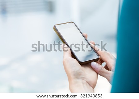 Closeup shot of woman\'s hand holding mobilephone. Girl using smartphone outdoor. Shallow depth of field with focus on woman hand holding cellphone. Close up of touch screen of smart phone.