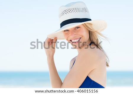 Woman wearing a straw hat and smiling. Portrait of a happy young woman in blue bikini with panama hat looking at camera with copy space.