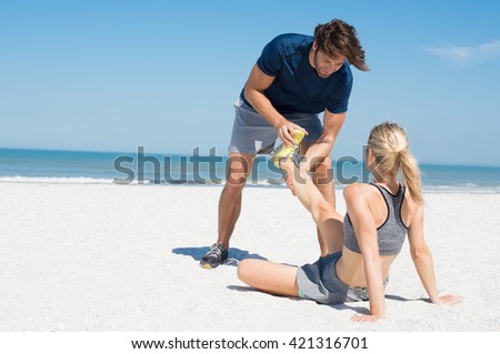 Man helping female runner in pain. Woman athlete having cramp during run. Sports woman with twisted sprained ankle, copys space.