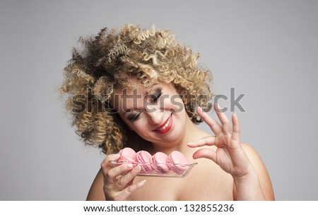bigger woman holding a trey with macarons trying to loose weight but cheating