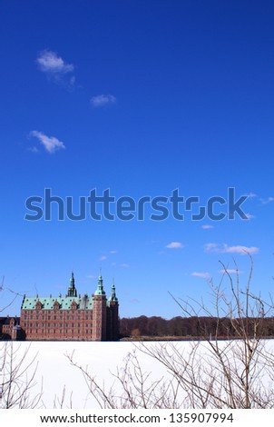 The castle lake on a sunny day with blue sky and the Frederiksborg Castle in the background which is the largest Renaissance Castle in Scandinavia