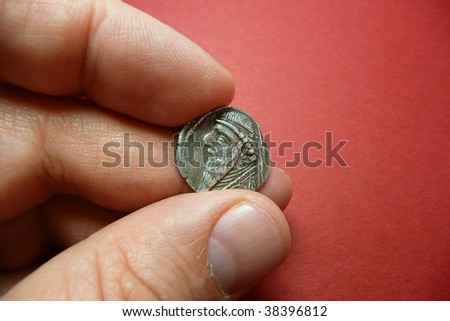 Ancient Parthian coin holded by the hand