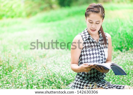 portrait beautiful young woman reading book sat grass smiling background summer meadow trees green grass