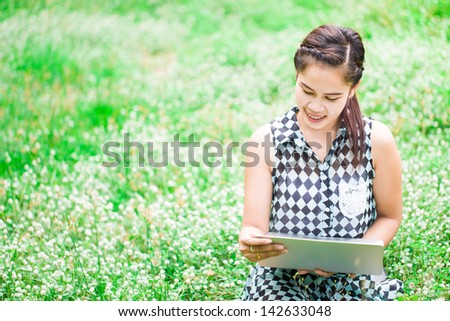 Beautiful asian woman with notebook in park with white flower