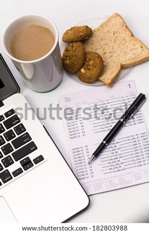 Close up of Book bank with a laptop computer, cookie, bread and cup of coffee