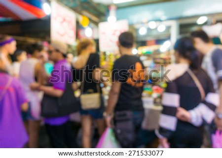 Blur tourists walk in shopping market, Chatuchak weekend market in Thailand.