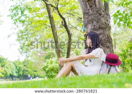 Asian smiling student with shoulder bag in park, Woman at summer green park