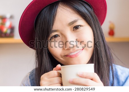 Beautiful asian woman drinking coffee in vintage cafe , Fashionable holding coffee