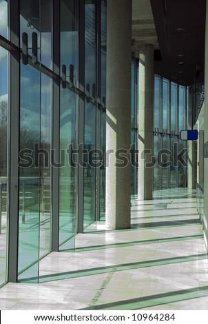 Modern office park interior. Glass wall and cement pillars. Polish Olympic Committee building.