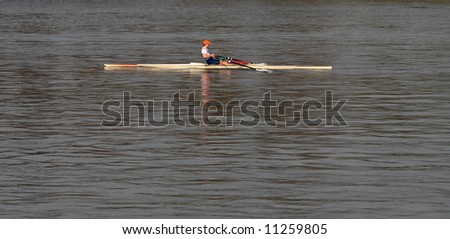 Young boy rowing on the river. Face blurred.