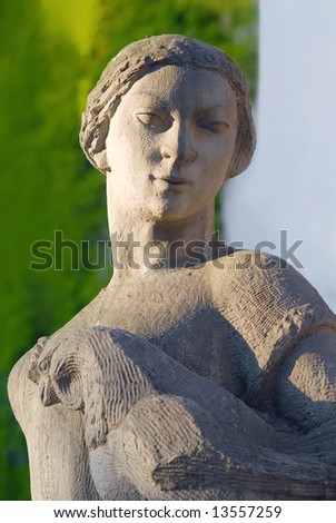 Stone sculpture of worker woman with cock. Social realism time from fifties last century.