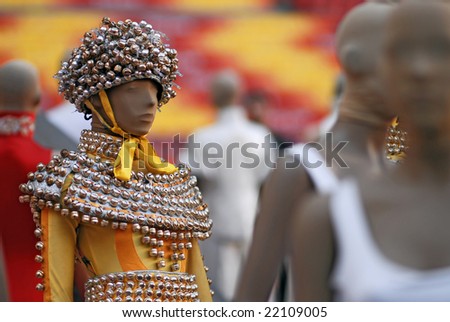 Chinese yellow clothes with metallic elements on female mannequin. Fashion background.