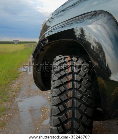 4x4 car on country wet road. All terrain tire.
