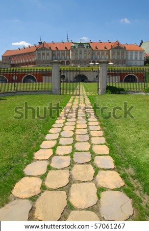 Riverside view of the Royal Castle in Warsaw. Summer time. Stone path with open gate.