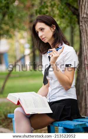 Student reading a book on the street