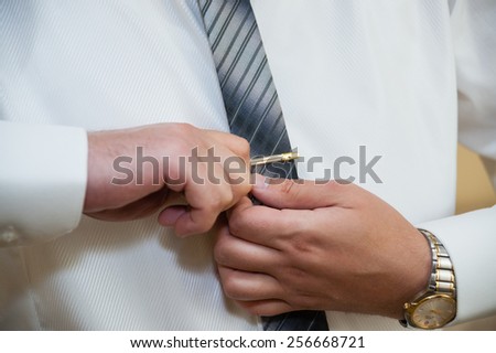 Man Fixing his Tie