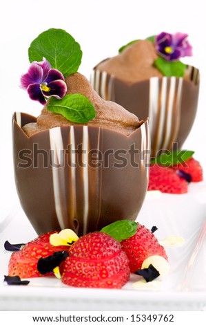 chocolate cream in chocolate cups garnish with flowers and fresh strawberry