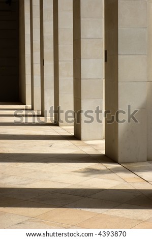Stone columns lit from the side with long shadows cast upon the ground