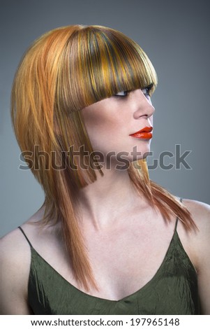 A woman with a peculiar haircut and hairstyle in studio, earth tones.