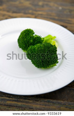 Green steamed broccoli on a white plate