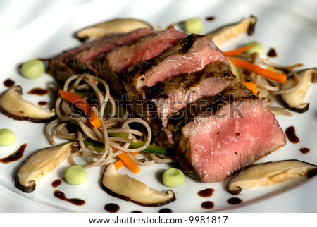Image of seared sliced beef with vegetable garnish